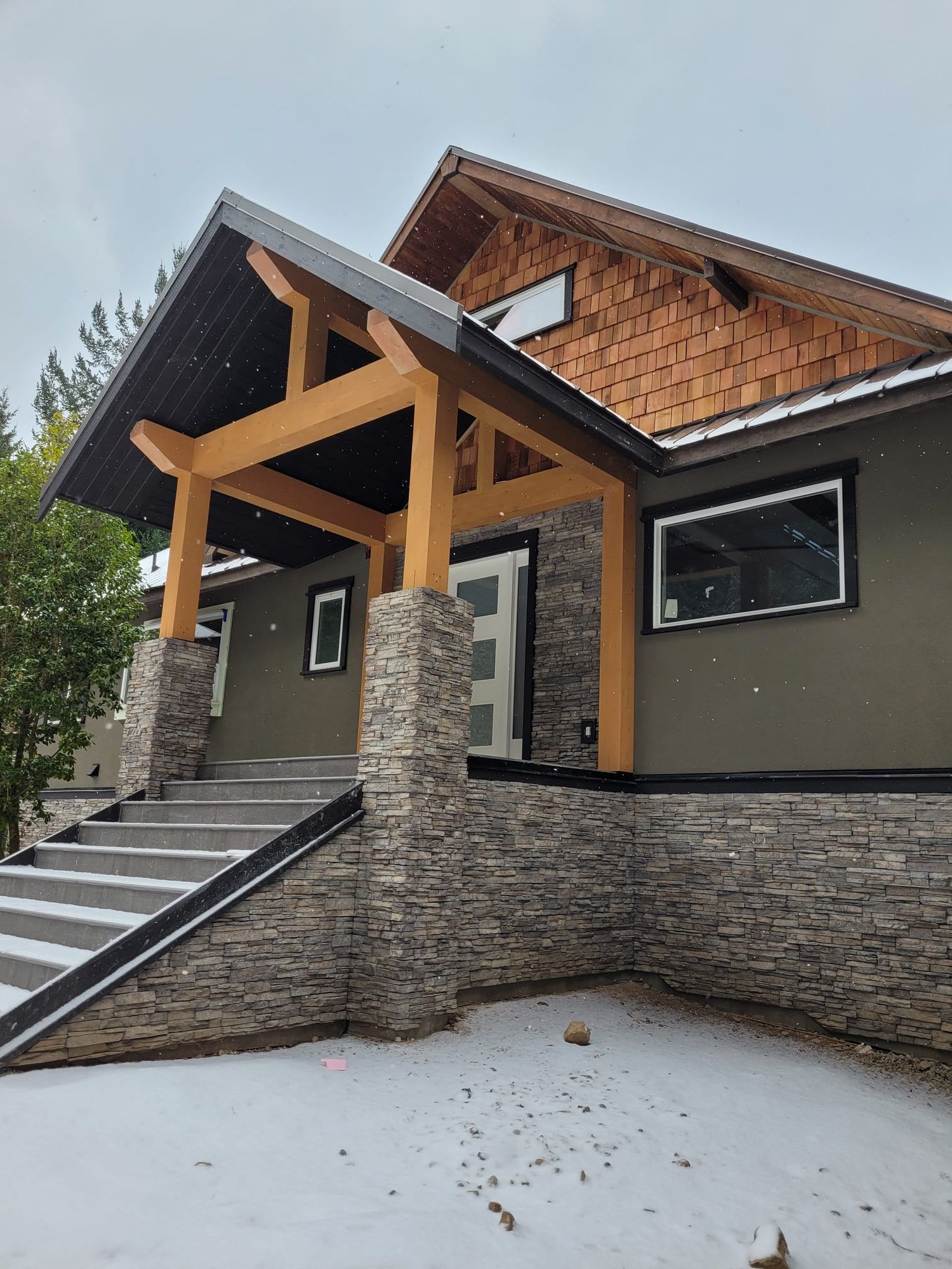 Timber frame entry addition — stone cladding, cedar shakes and completed exterior