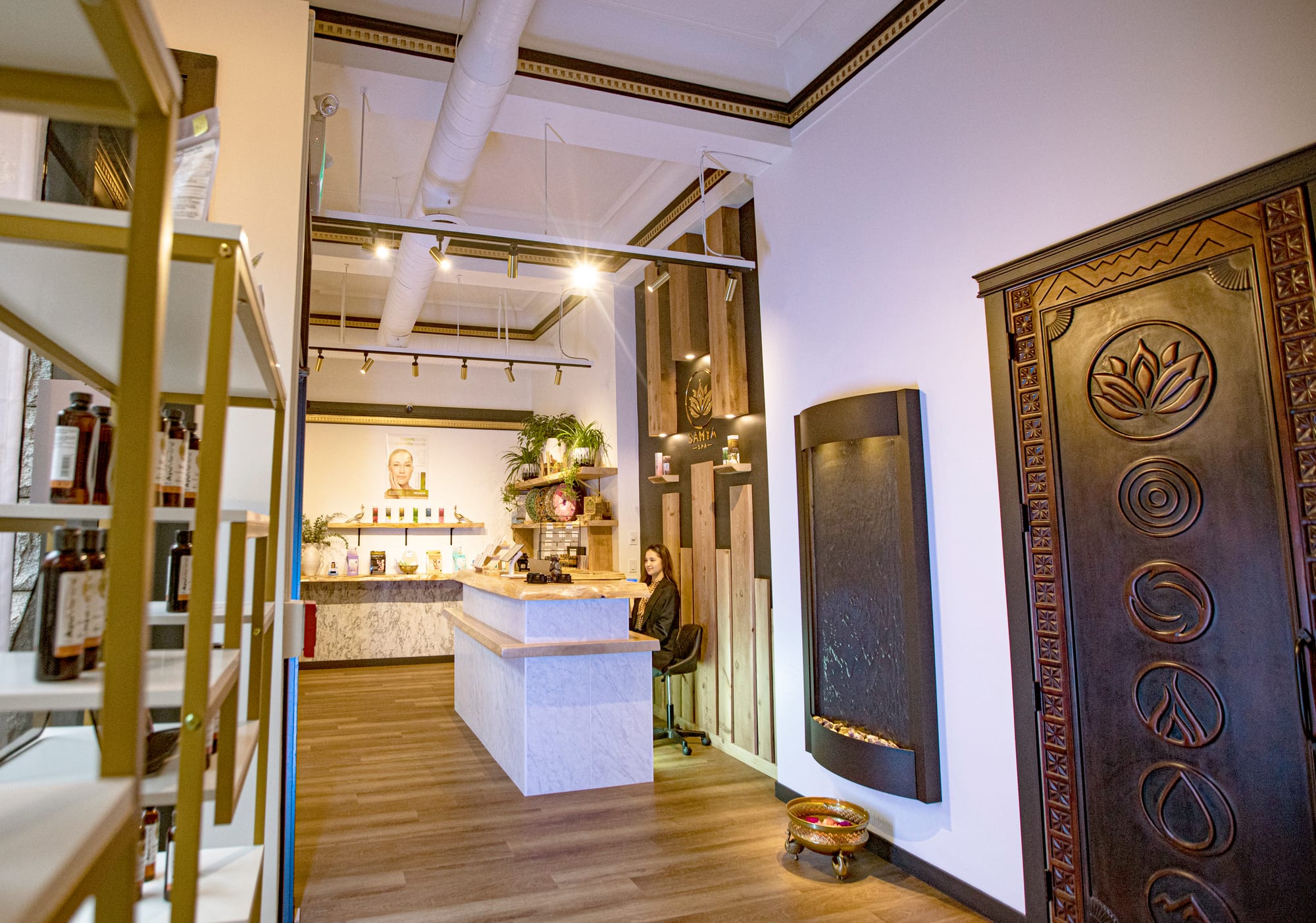 Samya Spa — reception and retail area with custom counter, carved decorative feature and track lighting