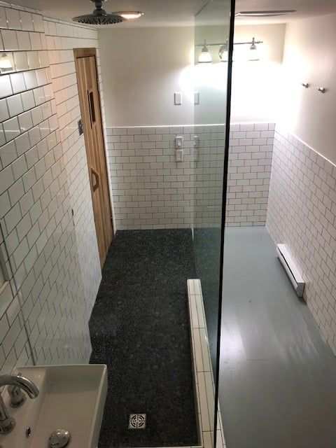 Walk-in shower — large-format white subway tile with pebble floor